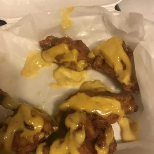 a box of fried chicken with cheese sauce