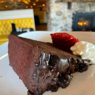 a slice of chocolate cake with whipped cream and strawberries