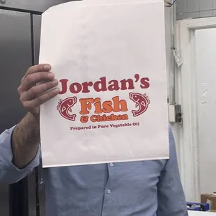 a man holding a paper bag over his face