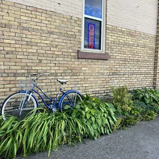 a bicycle parked against a brick wall