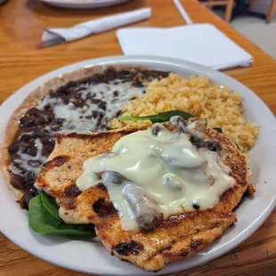 Swiss chicken on spinach with side of rice and black beans
