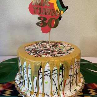Vanilla cake with buttercream icing and fresh strawberry and banana filling. I asked for paint splatter and paint drip for the design.