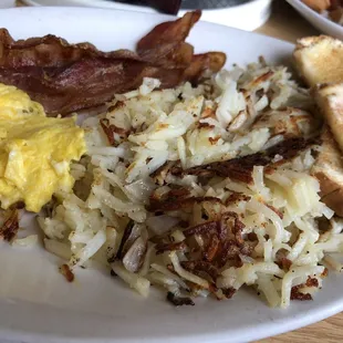 2 Eggs, Hash browns with Onions, Bacon, and Toast