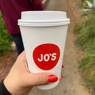 a hand holding a coffee cup