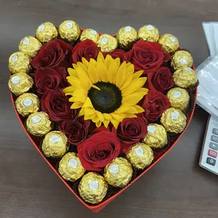 Red heart with chocolates and sunflowers