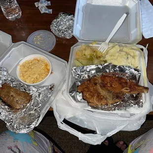 Pork chop plate with mashed potatoes and cabbage, and a slice of meat loaf with Mac and cheese.