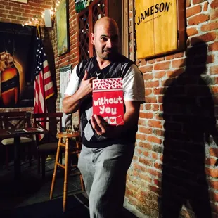 a man standing in front of a brick wall