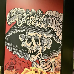 a skeleton with a hat and flowers