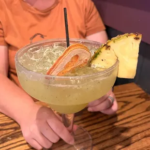 a person holding a glass of tequila