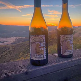 two bottles of wine on a wooden deck