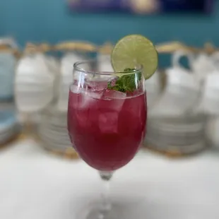 a glass of tea with a lime garnish