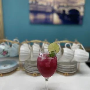 a glass of tea with a lime garnish