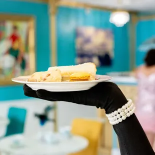 a woman holding a plate of pastries