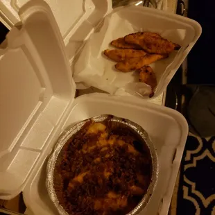 a takeout box with a pizza and french fries