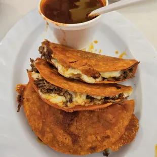 Quesabirria chivo tacos and consume.