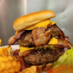 a hamburger with bacon, cheese, and lettuce