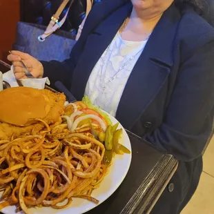 a woman sitting at a table with a plate of food