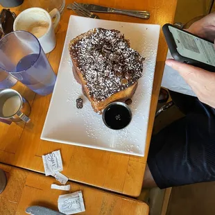 a plate of french toast with powdered sugar on top