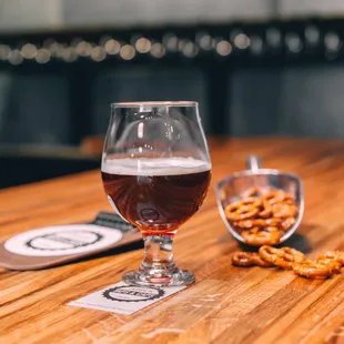 a glass of beer and pretzels