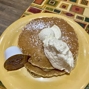 a plate of pancakes with whipped cream