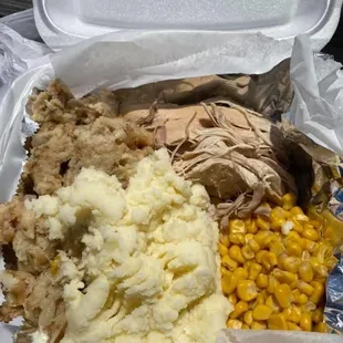 Roast turkey, mashed potatoes, dressing, corn, and crazy on the side.