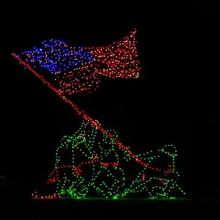 a lighted flag atop a mountain