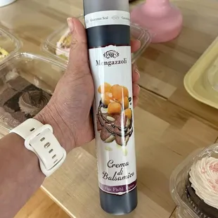 a person holding a bottle of cake batter