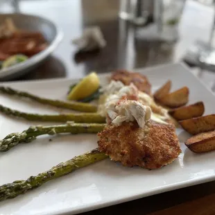 Potato encrusted fish with asparagus, potatoes and topped with crab and hollandaise sauce