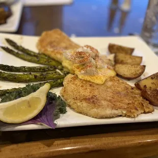 Potato encrusted fish with asparagus, potatoes and topped with crab and hollandaise sauce