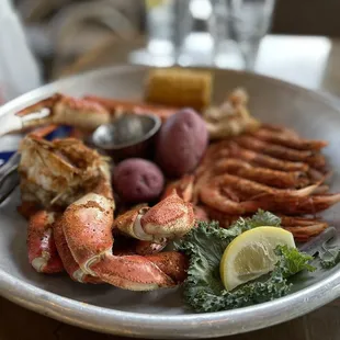 a plate of crab legs, potatoes, and potatoes
