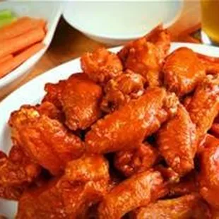 a plate of chicken wings and carrots