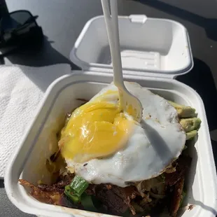 Loaded hash brown with bacon , avocado and egg