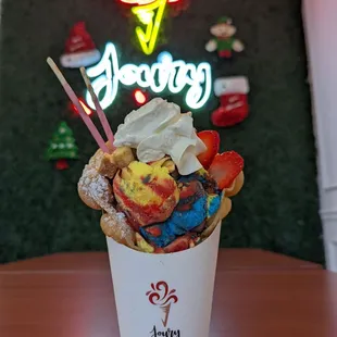 Bubble waffle with Superman ice cream, Pocky, cheesecake bites, strawberries, and whipped cream