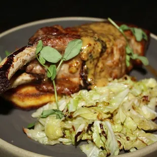 The Bone-In Berkshire Pork Chop is served with Crispy Polenta, Braised Savoy Cabbage &amp; Whole Grain Mustard Glaze.