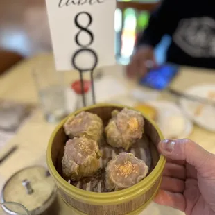 a person holding a bowl of doughnuts