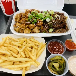 a tray of food with french fries and sauces