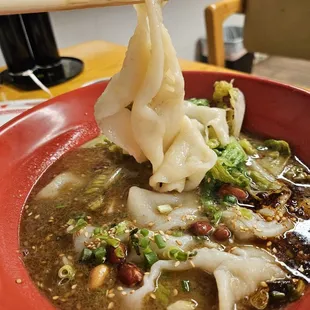 a bowl of soup and chopsticks