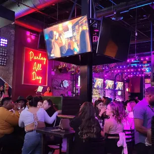 a large group of people sitting at tables in a bar