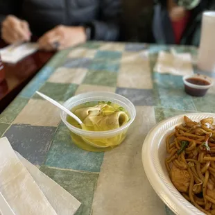 a plate of noodles and a bowl of soup