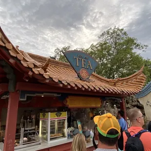 a group of people standing outside of a teahouse