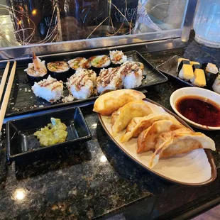 Assorted sushi rolls, nigiri, and gyoza.