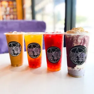 a row of four drinks on a table