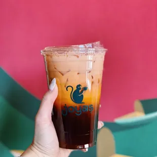 a hand holding a cup of iced coffee