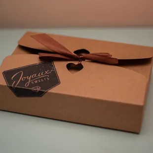 a brown box with a brown ribbon