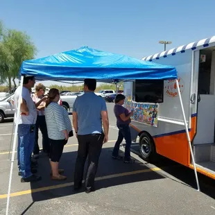 a group of people standing in front of a food truck