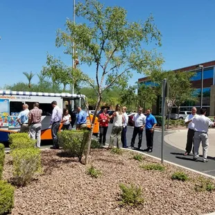 a group of people standing around a food truck