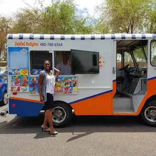 a woman standing in front of a food truck