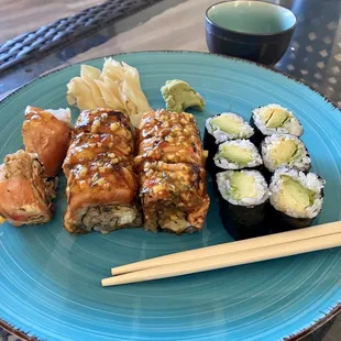 a plate of sushi and chopsticks