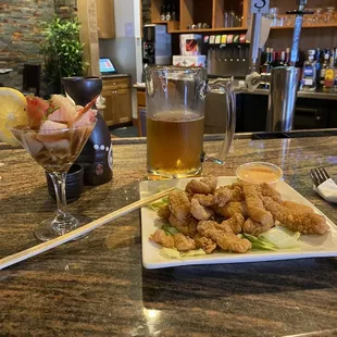 a plate of fried shrimp and a glass of beer