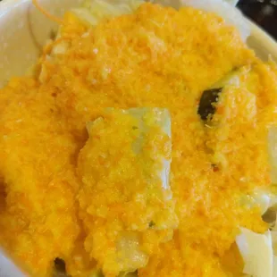 a bowl of food with cheese and broccoli